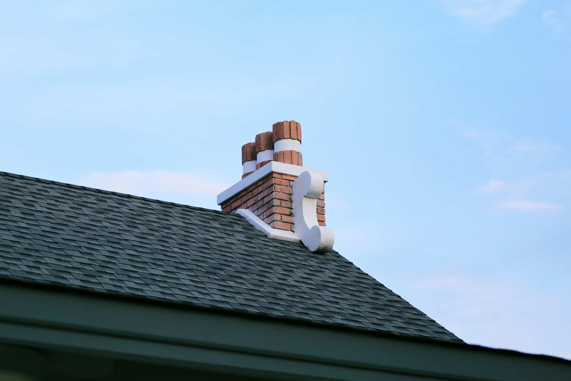 Chimney on house roof closeup blue sky background